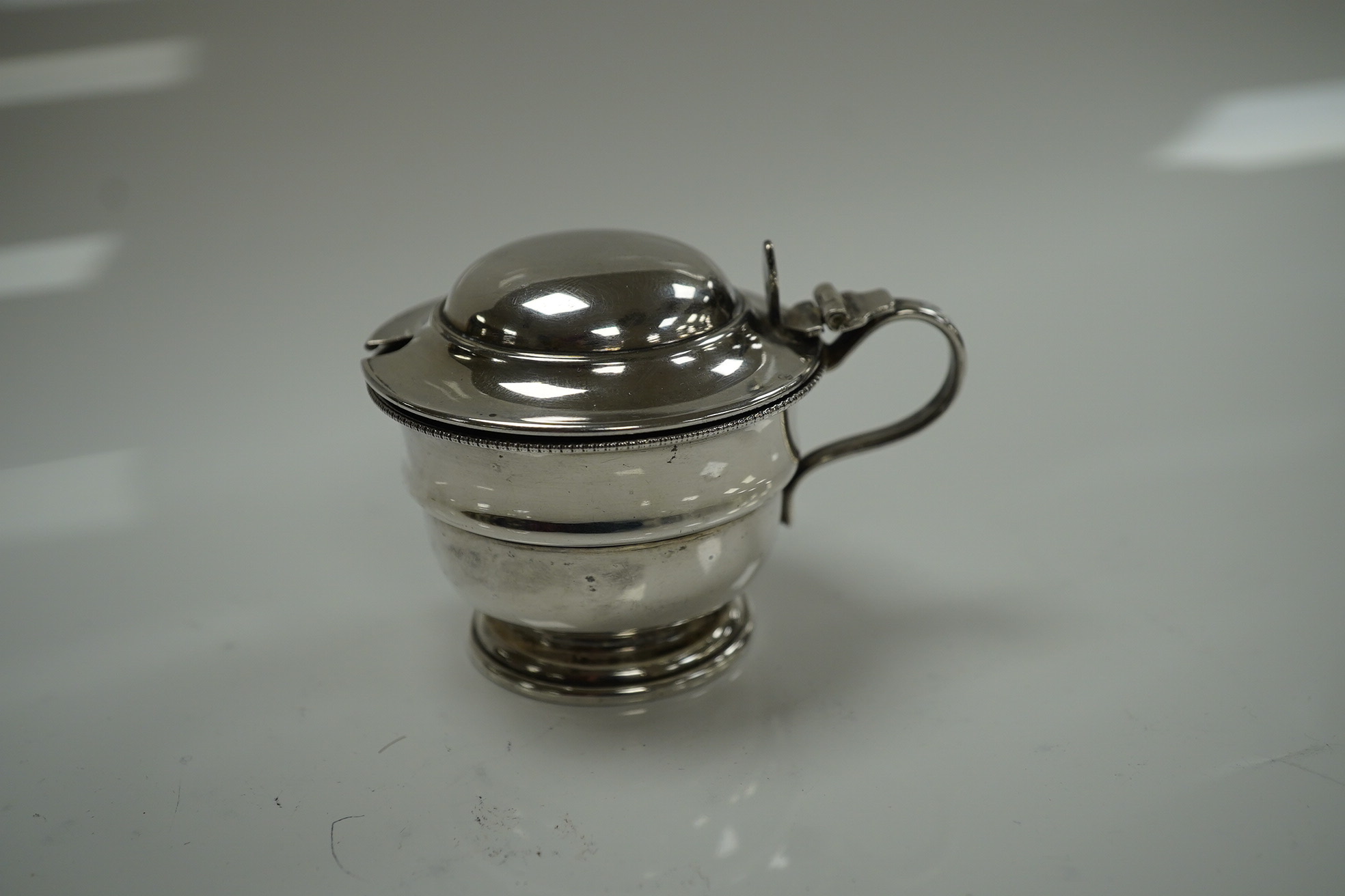 An Elizabeth II silver three piece condiment set, Sheffield, 1964, six assorted silver napkin rings and a stylish Austro Hungarian white metal pill box, by George Adam Scheid, 62mm. Condition - fair